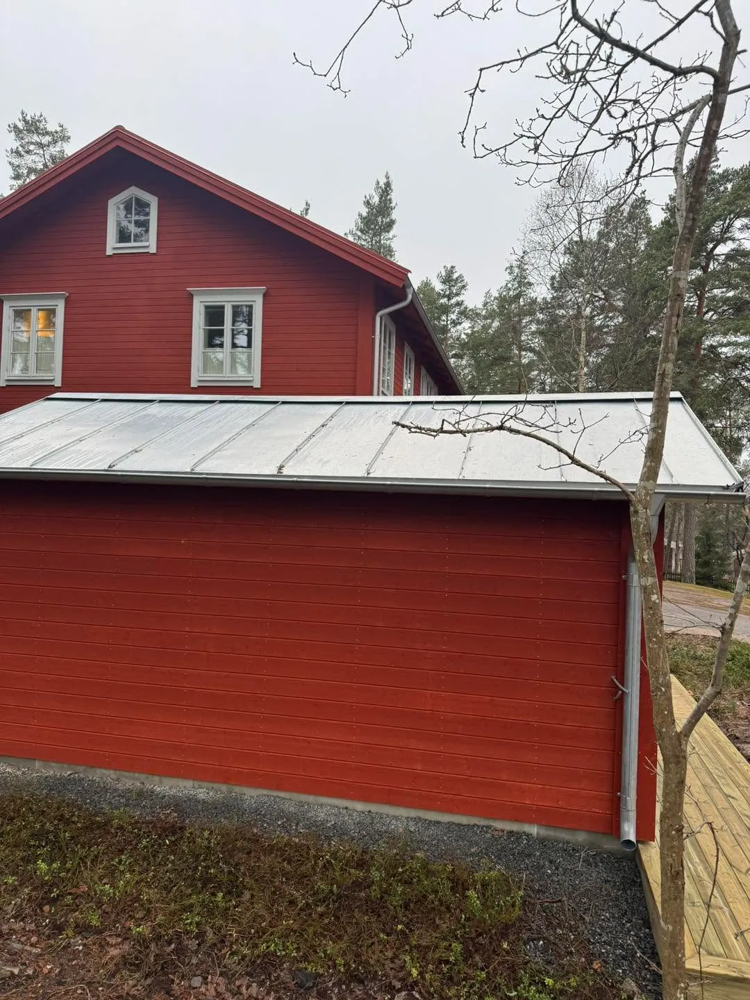Röd lada med nytt plåttak i skogen